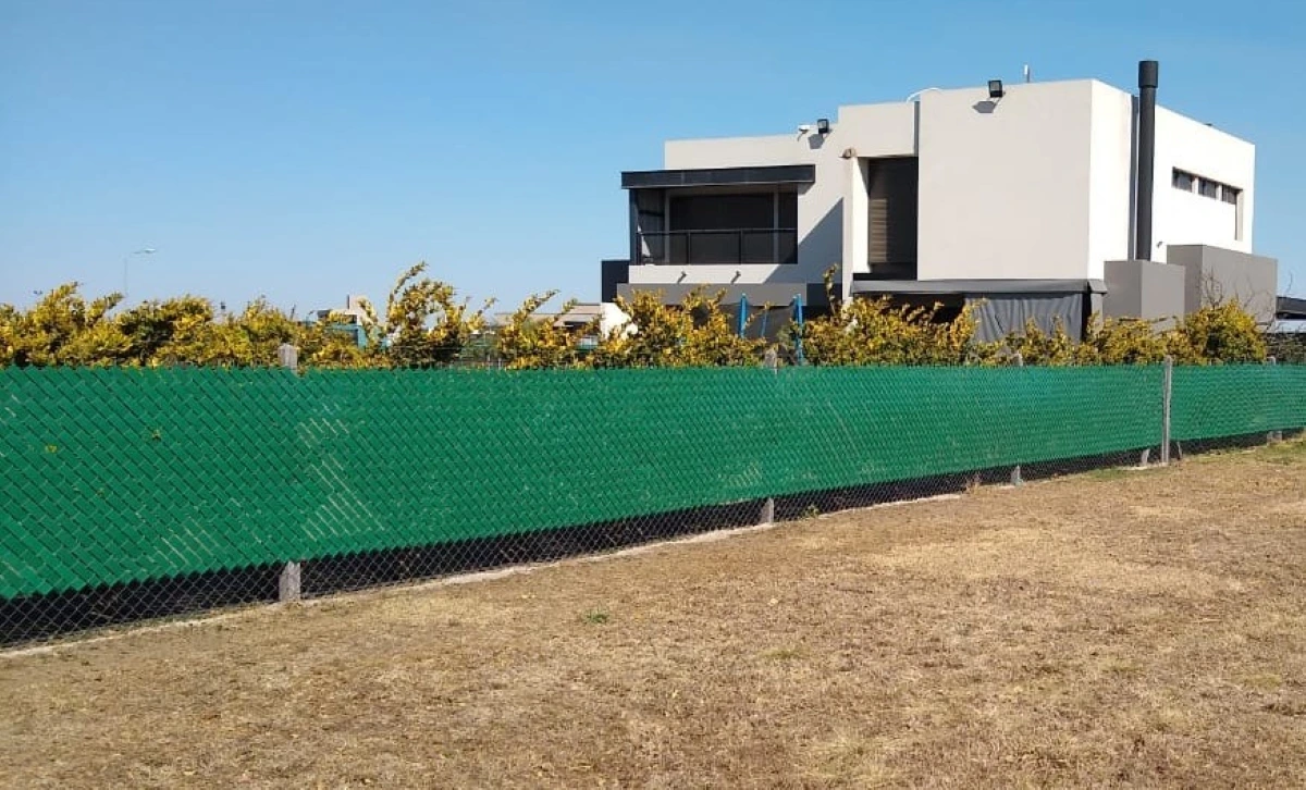 Cinta cubre cerco verde instalada en un alambrado perimetral, vista amplia